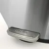 A close-up of the pedal of a stainless steel trash can. Produktbild-Vorschau