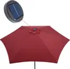 A close-up view of a red patio umbrella with a solar panel attachment. Produktbild-Vorschau