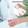 A hand is filling a pink water tank for a portable oral irrigator under a faucet. Náhľad obrázku produktu