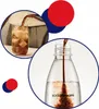 Collage showing a glass of cola with ice and syrup being poured into a SodaStream bottle. Produktbild-Vorschau