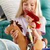A young girl is playing with a Toy Story Jessie action figure and her horse, Bullseye. The girl is smiling and holding the toys in a playful manner. Podgląd zdjęcia produktu