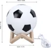 A soccer ball-shaped lamp on a wooden stand, with dimensions indicated by measurement lines. Produktbild-Vorschau