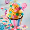 A close-up of a decorated cupcake with confetti scattered around it. Produktbild-Vorschau