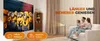 A family is watching a movie projected by a mini projector onto a wall. The image highlights features of the projector. Produktbild-Vorschau