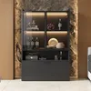 A modern display cabinet with glass doors and LED lighting, showcasing various items like bottles, bowls, and decorative objects, set against a textured stone and wood wall. Anteprima dell’immagine prodotto
