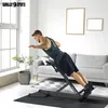 A man is performing a hyperextension exercise on a fitness machine in a living room. Produktbild-Vorschau