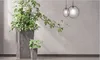 Two potted plants are placed in a modern interior setting with a concrete wall and pendant lights. Voir les images du produit