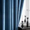 A close-up view of blue velvet curtains with a window and decorative candles in the background. Produktbild-Vorschau