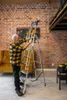 An elderly man is using a ladder in a room with a brick wall and a sofa. Náhľad obrázku produktu