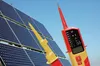 Two voltage testers are shown in front of a bank of solar panels under a clear blue sky. Náhľad obrázku produktu