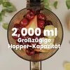 A top-down view of a juicer hopper filled with fruits, with text overlay highlighting capacity. Produktbild-Vorschau