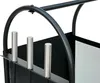 A close-up view of a black metal firewood rack with three silver metal rods in the foreground. Podgląd zdjęcia produktu