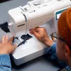 A person using a sewing machine. Produktbild-Vorschau