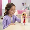 A young girl is playing with a doll in a bedroom. Voir les images du produit