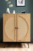 A wooden sideboard with rattan inserts is displayed against a dark teal wall. Produktbild-Vorschau