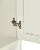 A close-up view of a cabinet hinge on a white wooden cabinet door. Náhľad obrázku produktu