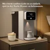 A modern water dispenser sits on a nightstand next to a bed, illuminated by soft ambient light. Produktbild-Vorschau