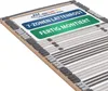 A close-up, angled view of a slatted bed base with informational labels attached. Produktbild-Vorschau