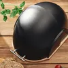 A black bread box with a wooden base sits on a wooden table, with a sprig of basil and slices of bread nearby. Produktbild-Vorschau