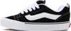 A side view of a black and white Vans sneaker. Voir les images du produit