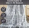 A light gray plush blanket is draped over furniture, with icons indicating indoor use, outdoor use, and travel. Náhled obrázku produktu