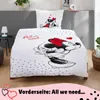 A white duvet cover and pillowcase featuring Mickey and Minnie Mouse graphics are displayed on a bed. Produktbild-Vorschau