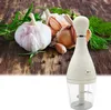 A kitchen gadget for chopping garlic and herbs is shown on a wooden surface with garlic bulbs and herbs. Náhľad obrázku produktu