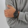 A person wearing a grey hoodie and a black Casio G-Shock watch. Produktbild-Vorschau