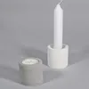 Two concrete candle holders, one with a tea light and one with a tall white candle, are displayed on a plain gray background. Podgląd zdjęcia produktu