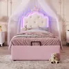 A child's bed with a princess-themed headboard and pink upholstery, set in a bedroom with sheer drapes and decorative wall molding. Produktbild-Vorschau