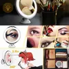 A collage of images showcasing a lighted makeup mirror and various makeup application scenarios, including a cartoon illustration and a packed suitcase. Produktbild-Vorschau
