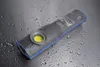 A flashlight lying on a wet, metallic surface. Produktbild-Vorschau