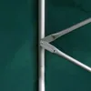 A close-up view of a metal frame mechanism attached to a green fabric surface. Produktbild-Vorschau