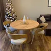 A dining table with chairs set up in a room with a Christmas tree and a sofa. Náhled obrázku produktu