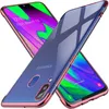 Two transparent phone cases with colored edges are crossed over each other, with a smartphone screen visible underneath one of them.