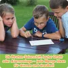 Three children are gathered around a wooden table outdoors, looking intently at an electronic circuit they are building. Náhled obrázku produktu