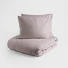A beige duvet cover and two pillowcases are neatly folded and stacked on a light gray background. Produktbild-Vorschau