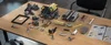 A collection of disassembled LEGO-like building blocks and an instruction manual are laid out on a wooden table. Voir les images du produit