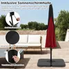 A patio scene with a red umbrella covered by a black protective sleeve, a sofa, and a table. Produktbild-Vorschau