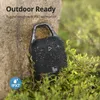 A black portable speaker with water droplets on it, leaning against a tree trunk and surrounded by green foliage. Voir les images du produit