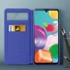 A blue flip case for a smartphone, with a credit card inserted. Náhled obrázku produktu