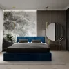 A modern bedroom with a dark blue upholstered bed as the main focus. Produktbild-Vorschau