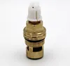 A close-up studio shot of a brass valve cartridge with a white plastic component on top, set against a plain white background. Produktbild-Vorschau