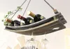 A hanging wine rack made from wood, holding several wine bottles and wine glasses. Produktbild-Vorschau