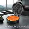 A waffle maker with heart-shaped waffles on a kitchen counter with a scenic view outside the window. Náhľad obrázku produktu