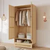 An open wooden wardrobe with clothes hanging inside and boxes on shelves. Náhled obrázku produktu