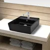 A black square ceramic sink with a silver faucet is placed on a white countertop, with folded white towels underneath. Produktbild-Vorschau