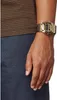 A close-up shot of a person's wrist wearing a gold digital watch. Podgląd zdjęcia produktu