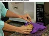 A person is placing a potato into a purple microwave potato bag next to an open microwave. Produktbild-Vorschau