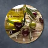 A round clock with an image of olives and olive oil on a wooden background. Produktbild-Vorschau